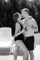 Kerl und ein Mädchen im Baden Anzüge sind entspannend, in der Nähe von das Blau Schwimmbad foto