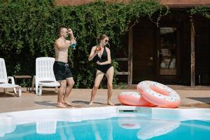 Kerl und ein Mädchen im Baden Anzüge sind entspannend, in der Nähe von das Blau Schwimmbad foto