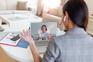 Geschäftsfrau Herstellung Video Anruf zu Geschäft Partner mit Laptop. Nahansicht Rückseite Aussicht von jung Frau haben Diskussion mit korporativ Klient. Fernbedienung Job Interview, Beratung, Mensch Ressourcen Konzept foto