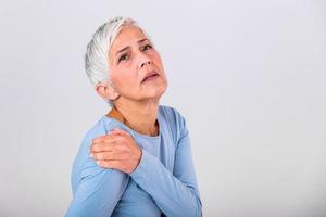 Seniorin mit Schulterschmerzen. ältere frau erträgt schreckliche schmerzen. Schulterschmerzen bei älteren menschen. Seniorin mit Schulterschmerzen foto