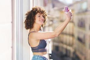 lächelnd Frau nehmen Selfie auf Balkon foto