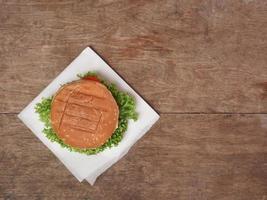 oben Aussicht von Appetit Burger gegen ein hölzern Tisch. Kopieren Raum foto