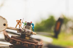 Miniaturmechaniker, die ein Fahrrad reparieren, Werkstattkonzept
