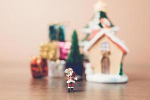 Miniatur-Weihnachtsmann, der eine Tasche trägt, Weihnachtsfeierkonzept foto