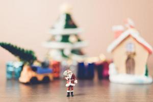 Miniatur-Weihnachtsmann, der eine Tasche trägt, Weihnachtsfeierkonzept foto