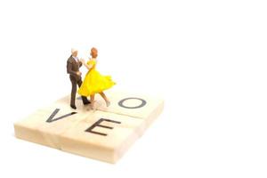 Miniaturpaar, das romantisch auf einem weißen Hintergrund, Valentinstagkonzept tanzt foto