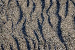 Wellen im das Sand foto