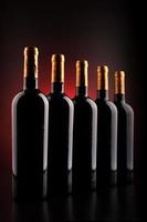 Weinflaschen mit schwarzem Hintergrund und rot foto