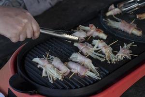 Kochen Speck eingewickelt Enoki Pilz gegrillt auf elektrisch Pfanne. foto