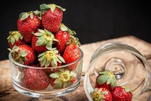 Erdbeeren in einem Glas auf einem Holztisch foto