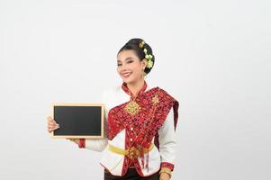 Porträt von schön thailändisch Frau im traditionell Kleidung posieren mit Tafel foto