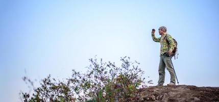 Wanderer Mann Stehen auf oben von Berg oder Cliff und suchen auf Senke foto