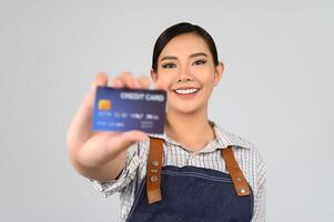 Porträt einer jungen Asiatin in einheitlicher Pose der Kellnerin mit Kreditkarte foto