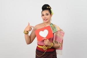 jung schön Frau im thailändisch nordöstlich Kostüm mit Karte im Herz Symbol foto