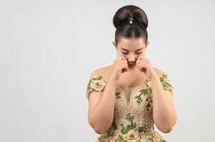 Porträt von schön asiatisch Braut im luxuriös Hochzeit Kleid im nachdenklich Pose foto