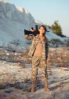 jung weiblich Soldat gekleidet im ein tarnen mit ein Gewehr im das Ort foto