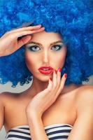 Porträt von ein jung schön Mädchen mit hell bilden im Blau Perücke foto