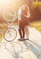 Kerl mit das Mädchen und Fahrrad draußen foto