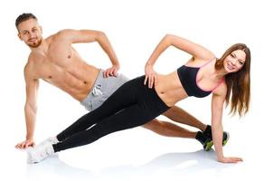 Sport attraktiv Paar - - Mann und Frau tun Fitness Übungen auf das Weiß foto