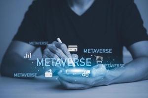 Neues Metaverse mit Icon-Business-Konzept, Business-Hand, die einen virtuellen Globus mit Finanz-Icons Zukunftstechnologie, Geschäftsziele, Online-Kommunikation, Grafikbildschirm-Icon eines Medienbildschirms, Big Data hält foto