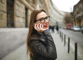 Geschäftsfrau Gehen Nieder das Straße während reden auf Clever Telefon foto