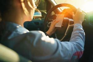 glücklich Frau Verwendet ein Navigator im ein Smartphone während Fahren ein Auto foto