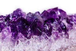 Makromineralstein lila Amethyst in Kristallen auf weißem Hintergrund foto