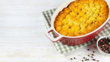 Shepherd's Pie oder Cottage Pie, traditionelles britisches Gericht auf weißem Holzhintergrund foto