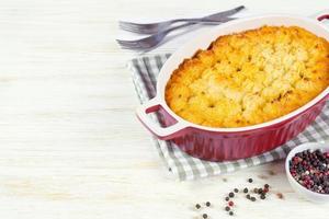 Shepherd's Pie oder Cottage Pie, traditionelles britisches Gericht auf weißem Holzhintergrund foto