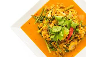 Gebratene Krabben mit Curry auf weißem Teller umrühren