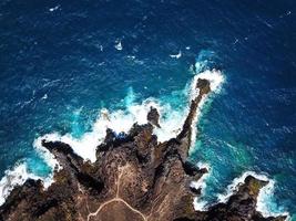 oben Aussicht von ein verlassen Küste. felsig Ufer von das Insel von Teneriffa. Antenne Drohne Aufnahmen von Meer Wellen erreichen Ufer foto