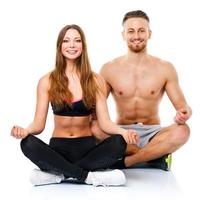 sportlich Paar - - Mann und Frau üben Yoga, tun Übung zum Entspannung foto