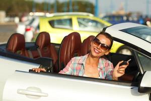 Frau Sitzung im ein Cabrio Auto mit das Schlüssel im Hand - - Konzept von Kauf ein benutzt Auto oder ein Vermietung Auto foto