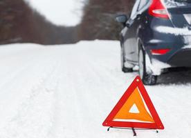 Nahansicht von rot Warnung Dreieck mit ein gebrochen Nieder Auto foto