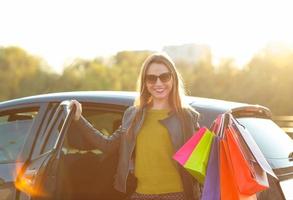 lächelnd kaukasisch Frau Putten ihr Einkaufen Taschen in das Auto foto