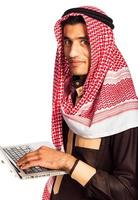 jung lächelnd arabisch mit Laptop isoliert auf Weiß foto