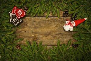 Weihnachten Rand mit Tanne Baum Geäst, Zapfen und Weihnachten Dekorationen auf hölzern Bretter bereit zum Ihre Design foto
