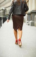 Frau tragen elegant Rock und rot hoch Hacke Schuhe im alt Stadt, Dorf foto