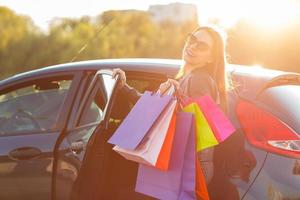 lächelnd kaukasisch Frau Putten ihr Einkaufen Taschen in das Auto foto