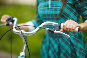 Mädchen Gehen mit ihr Fahrrad draußen foto