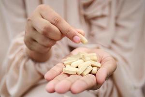 Frauen Hand wählen Kräuter- Medizin Kapsel , foto