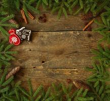 Weihnachten Baum Ast mit Zapfen, Zimt, Diptam und Weihnachten Dekorationen auf hölzern Hintergrund mit Copyspace foto