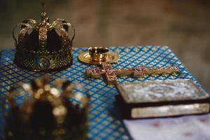 orthodox golden Hochzeit Kronen, Kirche Symbole, Kirche Bücher, Evangelium auf das Tisch. selektiv Fokus foto