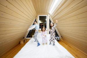 Kinder im Sanft warm Pyjama spielen beim hölzern Kabine heim. Konzept von Kindheit, Freizeit Aktivität, Glück. Bruder und Schwestern haben Spaß und spielen zusammen. foto