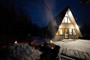 Holz gefeuert Grill gegen Dreieck Land Haus beim Nacht. foto