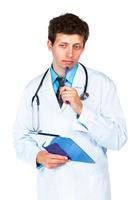 Porträt von überlegen jung männlich Arzt Schreiben auf ein Patienten medizinisch Diagramm auf Weiß foto