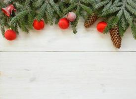Weihnachten Baum Geäst mit Zapfen, Weihnachten Dekorationen auf Weiß hölzern Textur bereit zum Ihre Design foto