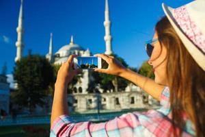 Mädchen im das Hut Herstellung Foto durch das Smartphone in der Nähe von das Blau Moschee, Istanbul