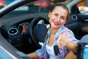 jung Frau Sitzung im ein Cabrio Auto mit das Schlüssel im Hand - - Konzept von Kauf ein benutzt Auto oder ein Vermietung Auto foto