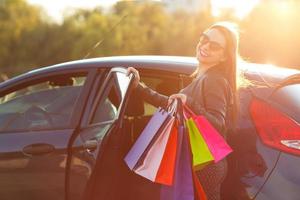 lächelnd kaukasisch Frau Putten ihr Einkaufen Taschen in das Auto foto